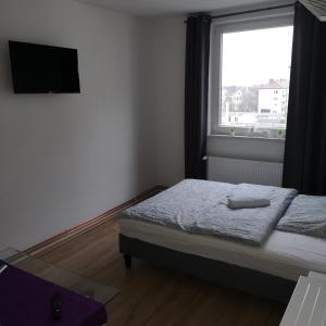 a small bedroom with a bed and a window at Hafenstraße 98 - Apartment im 4. Obergeschoss in Bremerhaven +7 photos