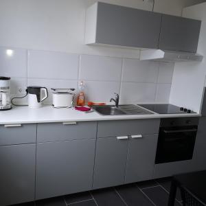 Biała kuchnia ze zlewem i kuchenką w obiekcie Hafenstraße 98 - Apartment im 4. Obergeschoss w mieście Bremerhaven