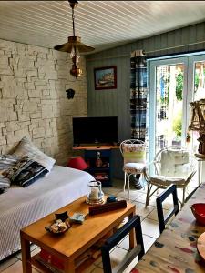 a living room with a bed and a table and a tv at La Breizh'îlienne in Groix