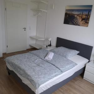 ein Schlafzimmer mit einem Bett und einem Handtuch darauf in der Unterkunft Hafenstraße 98 - Apartment im 4. Obergeschoss in Bremerhaven