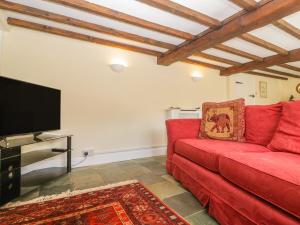 un soggiorno con divano rosso e TV a schermo piatto di Field View a Taunton
