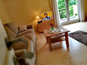 una sala de estar con un sofá y una mesa en Ferienwohnung A Casa Mia, en Gengenbach