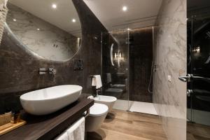 a bathroom with a sink and a toilet and a shower at Growel Exclusive Suites San Pietro in Rome