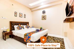 a hotel room with a bed and a tv at FabExpress Travelers Lodge in Jaipur