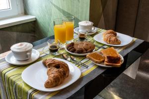 a table topped with plates of pastries and coffee and orange juice at Growel Exclusive Suites San Pietro in Rome
