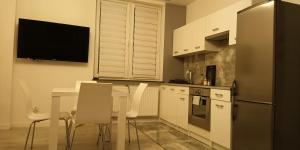 a kitchen with a table with chairs and a refrigerator at Apartament Białystok Center in Białystok