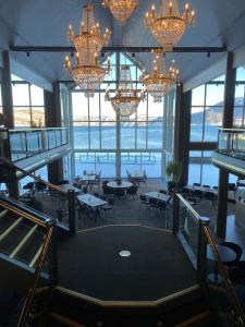 a restaurant with chandeliers and tables and chairs at Rognan Hotel in Rognan