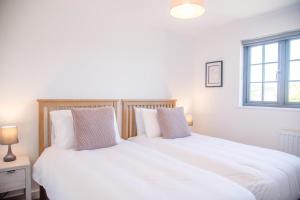 two beds sitting next to each other in a bedroom at 3 Oaks Court, Thorpeness in Thorpeness