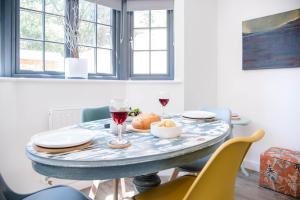 a table with glasses of wine and food on it at 3 Oaks Court, Thorpeness in Thorpeness