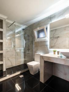 a bathroom with a toilet and a glass shower at Roys Blu in Kavos