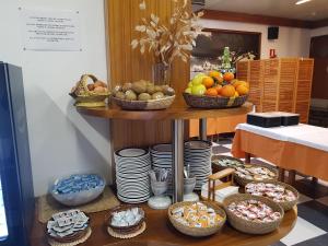 una mesa llena de cestas de frutas y platos en Hotel S´Aguarda, en Cadaqués