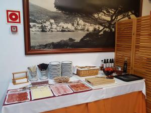 una tavola con cibo e piatti su un tavolo di Hotel S´Aguarda a Cadaqués