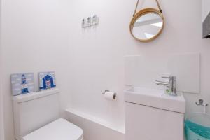 a white bathroom with a toilet and a sink at 4 Sea View Walk, Pakefield in Pakefield