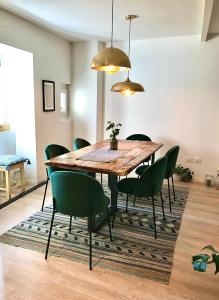 een eetkamer met een houten tafel en groene stoelen bij Locanda 53 in Arco