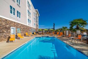 a pool at a hotel with orange chairs and tables at La Quinta by Wyndham Forsyth in Forsyth