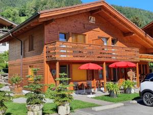 a house with two red umbrellas in front of it at Chalet Gafri -Boutique B&B - comfort and hospitality - near Interlaken in Wilderswil