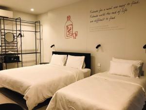 two beds in a room with a writing on the wall at CHERN Bangkok in Bangkok