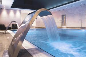 a swimming pool with a water slide in a building at Fistral Beach Hotel and Spa - Adults Only in Newquay