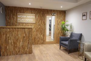 a lobby with a work hard play hard sign on a wall at Fistral Beach Hotel and Spa - Adults Only in Newquay