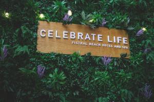 a sign that says celebrate life in a bush at Fistral Beach Hotel and Spa - Adults Only in Newquay