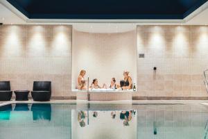 three women sitting in a tub in a swimming pool at Fistral Beach Hotel and Spa - Adults Only in Newquay