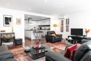 a living room with two couches and a kitchen at Lisbon Rentals Chiado in Lisbon