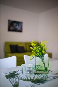 einen Tisch mit einer Vase mit gelben Blumen darauf in der Unterkunft Afrodita in Gornji Karin