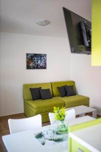 ein Wohnzimmer mit einem grünen Sofa und einem Tisch in der Unterkunft Afrodita in Gornji Karin