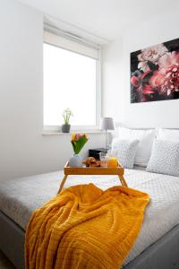 a bed with a blanket and a table on it at EASY RENT Apartments - SMART 708 in Lublin