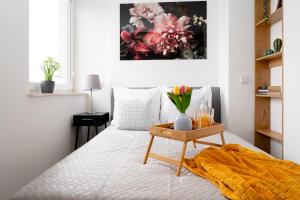 a bedroom with a bed with a table with flowers on it at EASY RENT Apartments - SMART 708 in Lublin