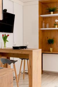 a kitchen with a wooden table with two wine glasses at EASY RENT Apartments - SMART 708 in Lublin