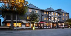 a large black and white building on a street at Hotel Gasthof zur Post in Winterberg