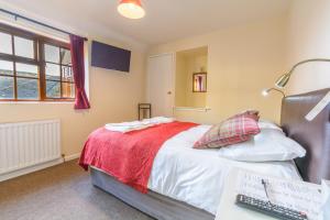 a bedroom with a bed and a desk with a keyboard at Volunteer Inn in Chipping Campden