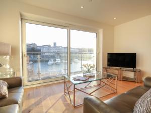 a living room with a glass table and a large window at Harbourside Haven Apartment 4 in Weymouth