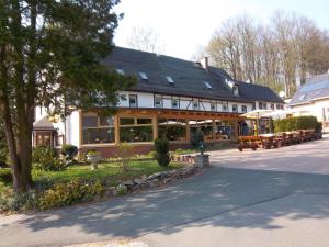 a large building with benches in front of it at Gaststätte & Pension Oelmuehle in Oberschöna