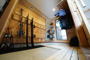 a room with a bunch of skis hanging on the wall at Tombi Lodge in Iiyama
