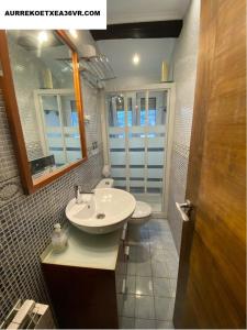 y baño con lavabo, aseo y espejo. en Aurrekoetxea 36 Vacation Rental, 5D, en Bermeo