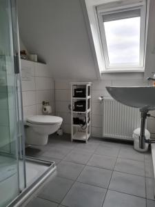 ein Badezimmer mit Waschbecken und Toilette und einem Fenster in der Unterkunft Wohnung Burgstaaken in Fehmarn + 11 Fotos