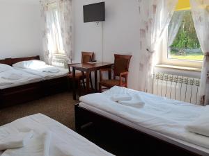 Centrum Turystyki Wiejskiej Alicja في Księżpol: غرفة بسريرين وطاولة ونافذة