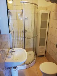 a bathroom with a sink and a shower and a toilet at Vivi studio apartments in Mali Lošinj