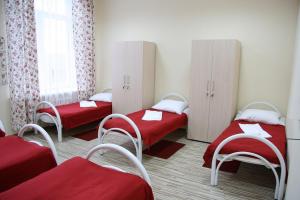 モスクワにあるRomashka Hostelのベッド2台と椅子、窓が備わる客室です。