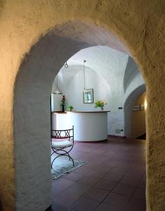um corredor com uma mesa num edifício com uma arcada em B&B Unterhabsbergerhof em Appiano sulla Strada del Vino