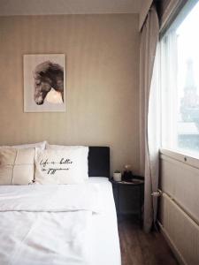 a bedroom with a bed with a picture of a horse on the wall at 2ndhomes Tampere "Rautatieasema" Apartment - Heartful New Apt with Balcony in the City Center in Tampere