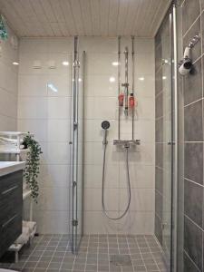 a shower with a glass door in a bathroom at 2ndhomes Tampere "Rautatieasema" Apartment - Heartful New Apt with Balcony in the City Center in Tampere