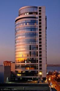 a tall building with lights on in a city at Seven Eleven Most City Hotel&SKYTECH in Dnipro