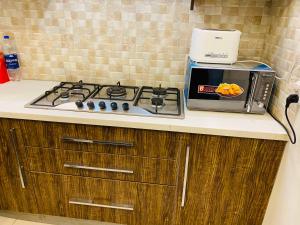 a kitchen counter with a stove and a microwave at Royal Three Bed Villa Full House Dha 6 Lahore in Lahore +8 photos