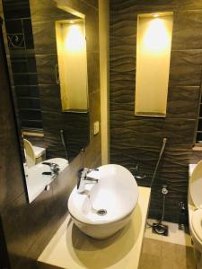 La salle de bains est pourvue d'un lavabo, de toilettes et de miroirs. dans l'établissement Independent Full House Dha 6 Lahore, à Lahore