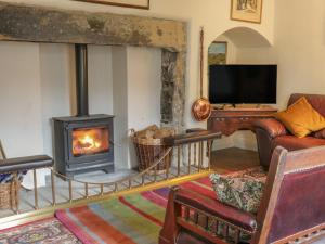 a living room with a fireplace and a television at Bridgend Cottage in Skipton