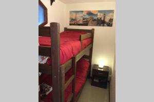 1 dormitorio con 2 literas con sábanas rojas en Apto con parrilla en balcón a 80 de la playa! Con wifi en Punta del Este