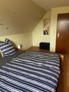ein Schlafzimmer mit einem blau-weißen gestreiften Bett in der Unterkunft Hof Beuck in Travenhorst + 21 Fotos
